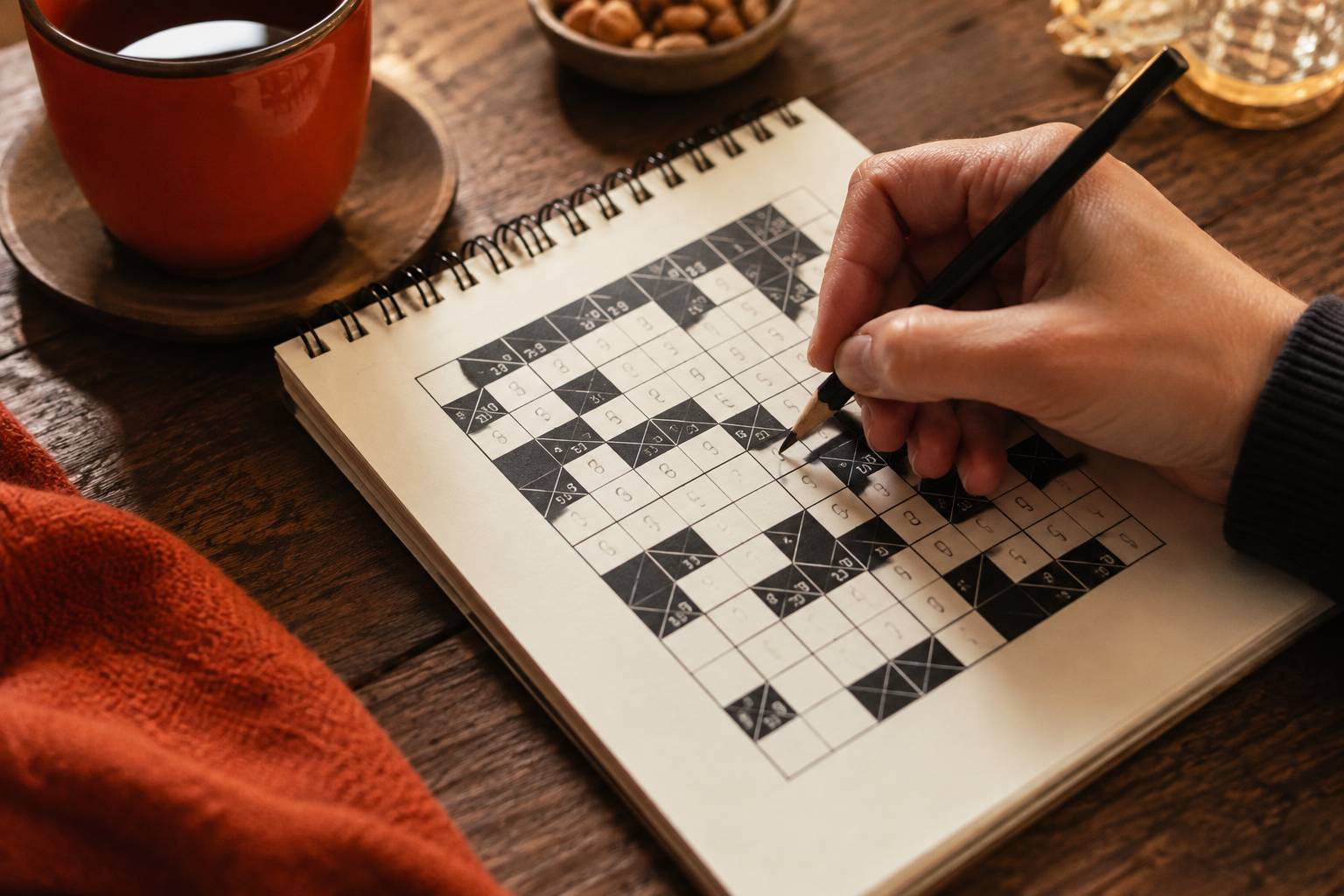 Main écrivant un chiffre dans une grille de kakuro avec un crayon, gros plan de résolution
